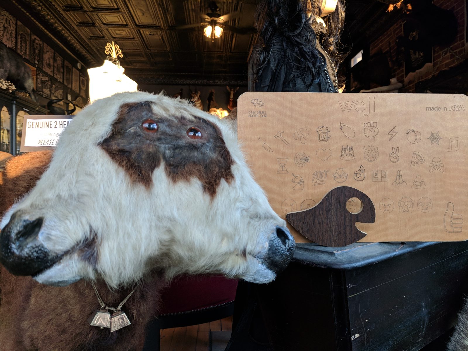 A two-headed calf taxidermy mount next to the engraved Weji board