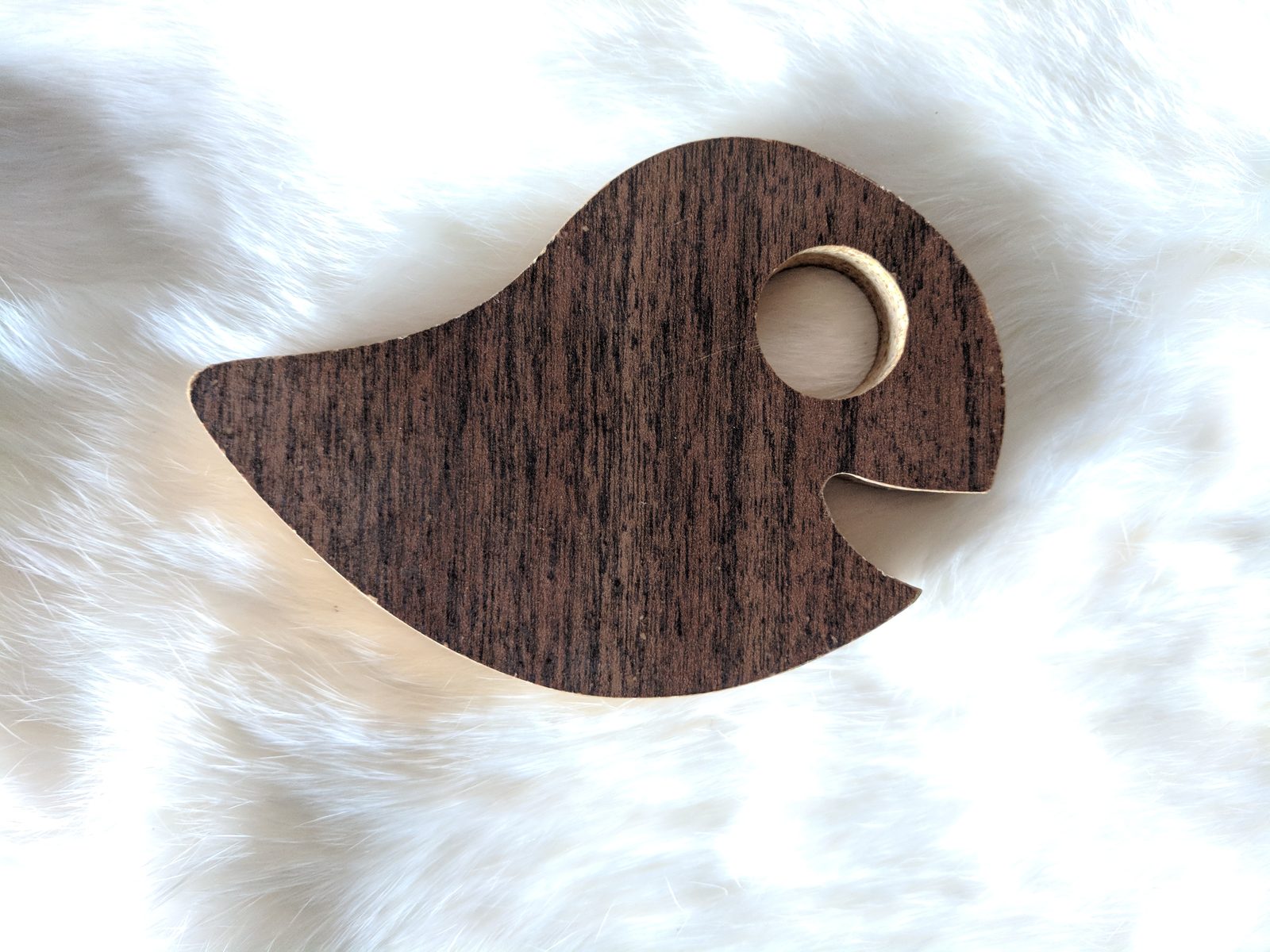 Close-up of the walnut ghost-shaped planchette with its round viewing window